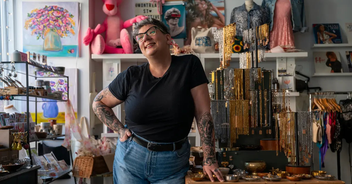 Person smiling in a store filled with various items and decorations.