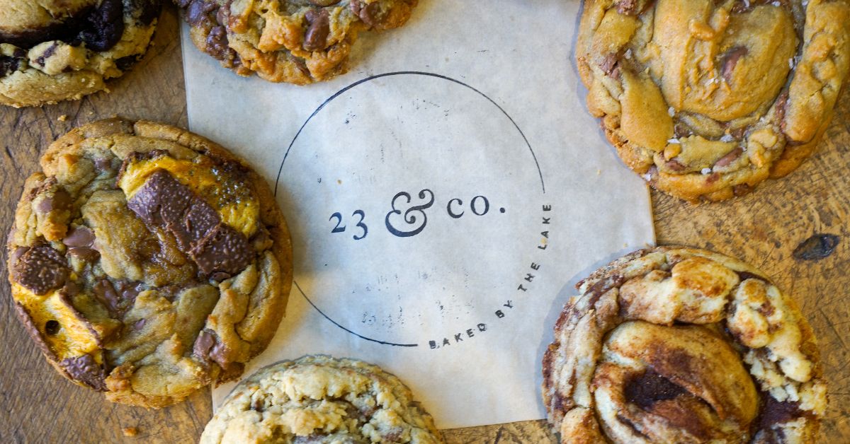 Cookies arranged around a circular logo for 23 & Co. on parchment paper.