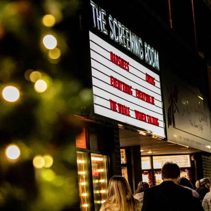 The Screening Room sign with people gathered outside at night