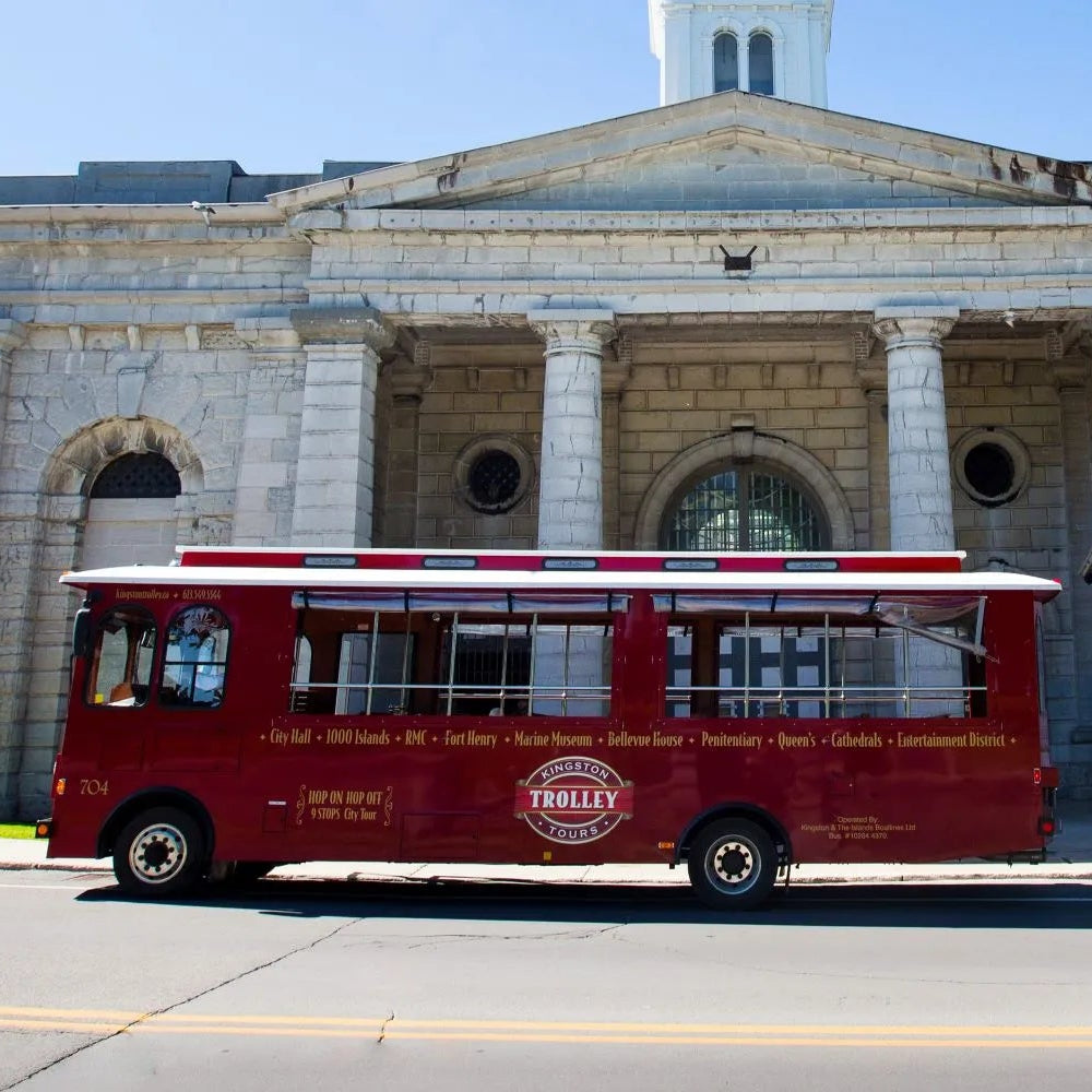 Red tour bus in front of a large stone building