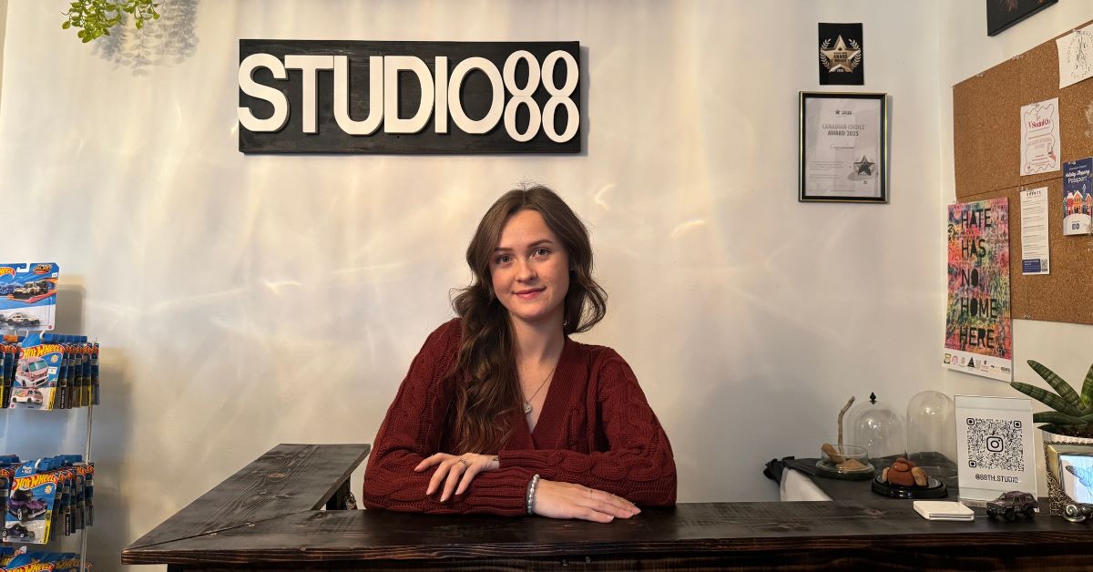 Woman sitting at a reception desk in a studio.
