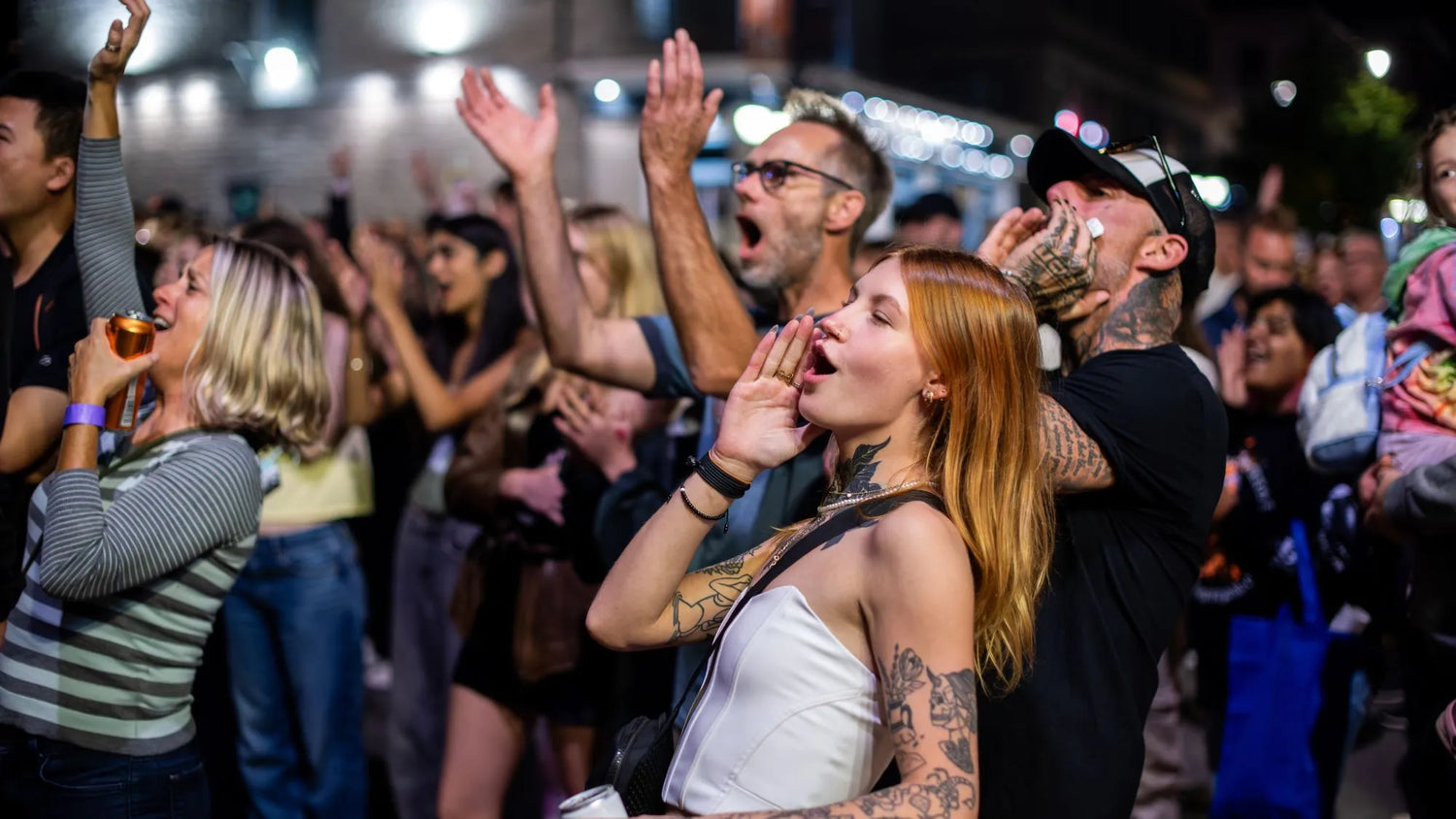 A crowd enjoying a lively event, cheering and celebrating together in downtown Kingston